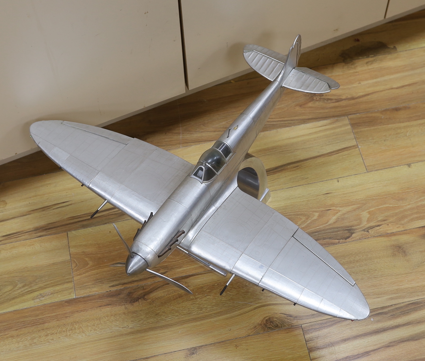 A sheet metal model of a WWII Spitfire on a stand, applied plaque to the base, 60cm in length